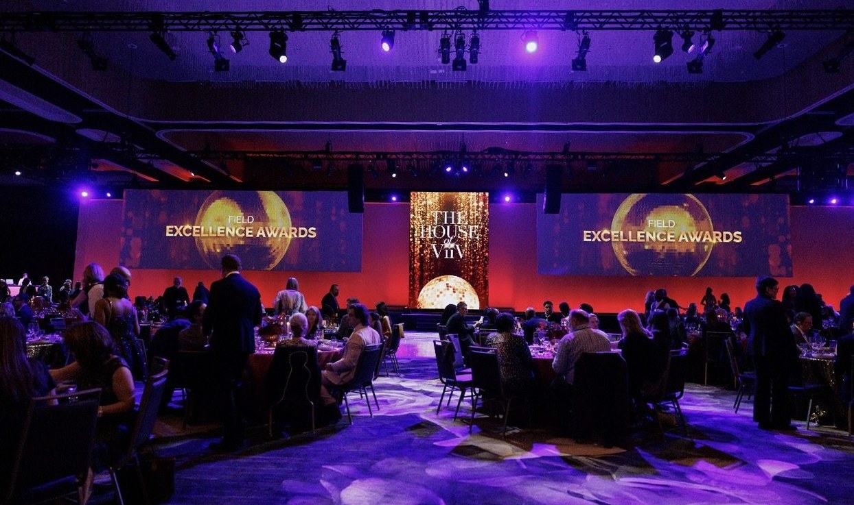 Field Excellence Awards dinner in a ballroom with LED screens and purple lighting